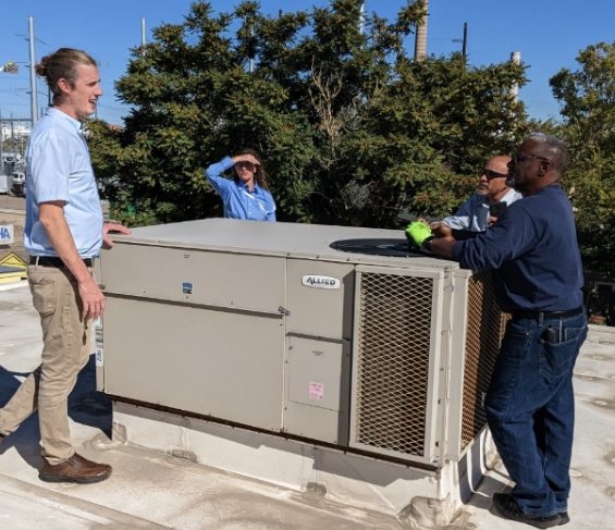 Miles Hayes walking a rooftop unit with a facilities team